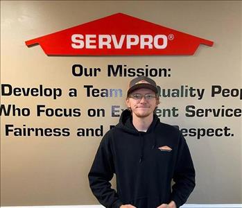 Employee in front of mission statement